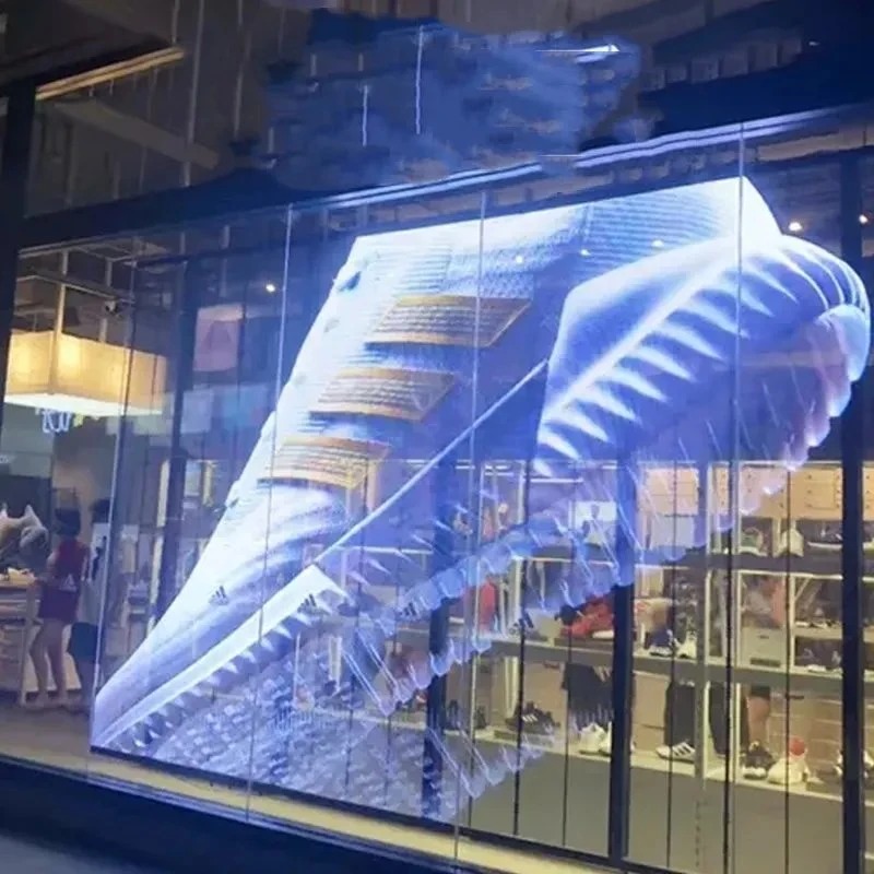 Adidas storefront with transparent LED window content at night
